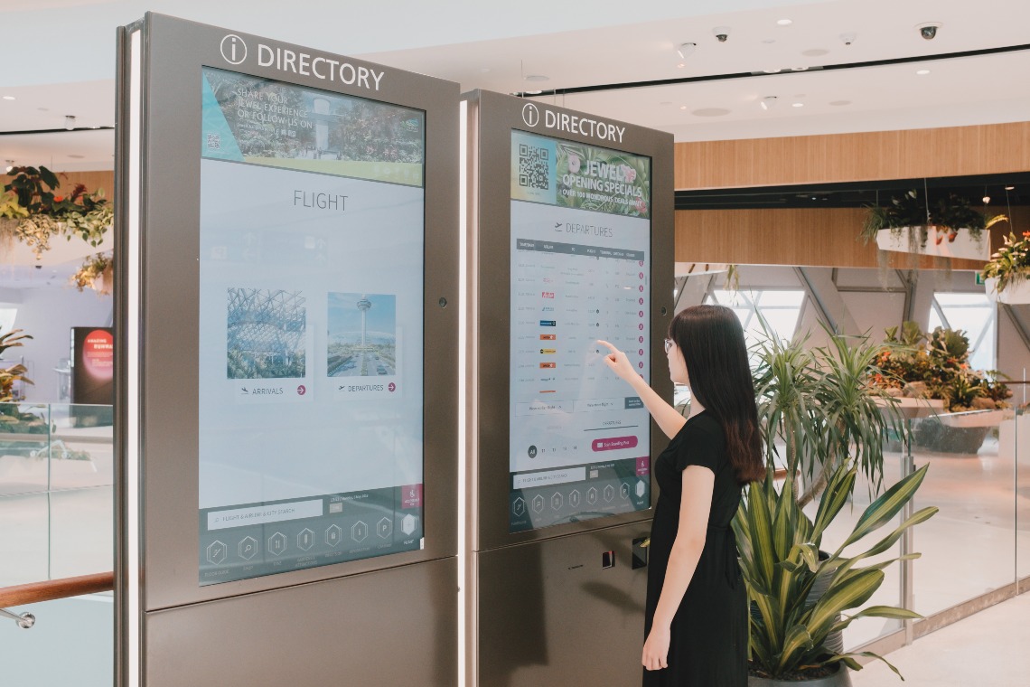 A lady looking for information at the interactive information boards in Jewel.
